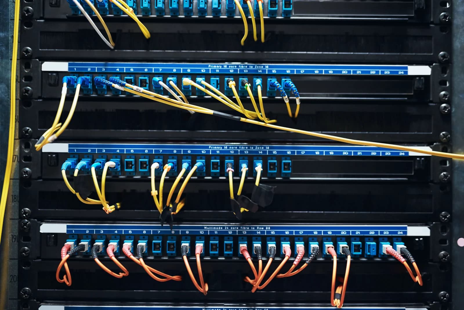 Fibre patch cables connected to panels in a network rack