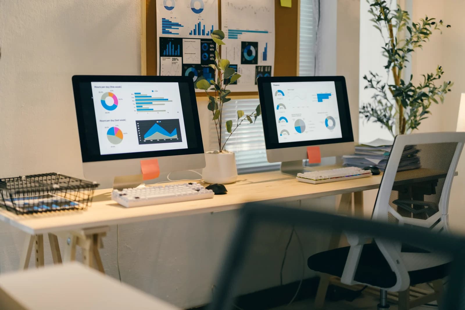 Two desktop monitors displaying charts at a tidy office workstation