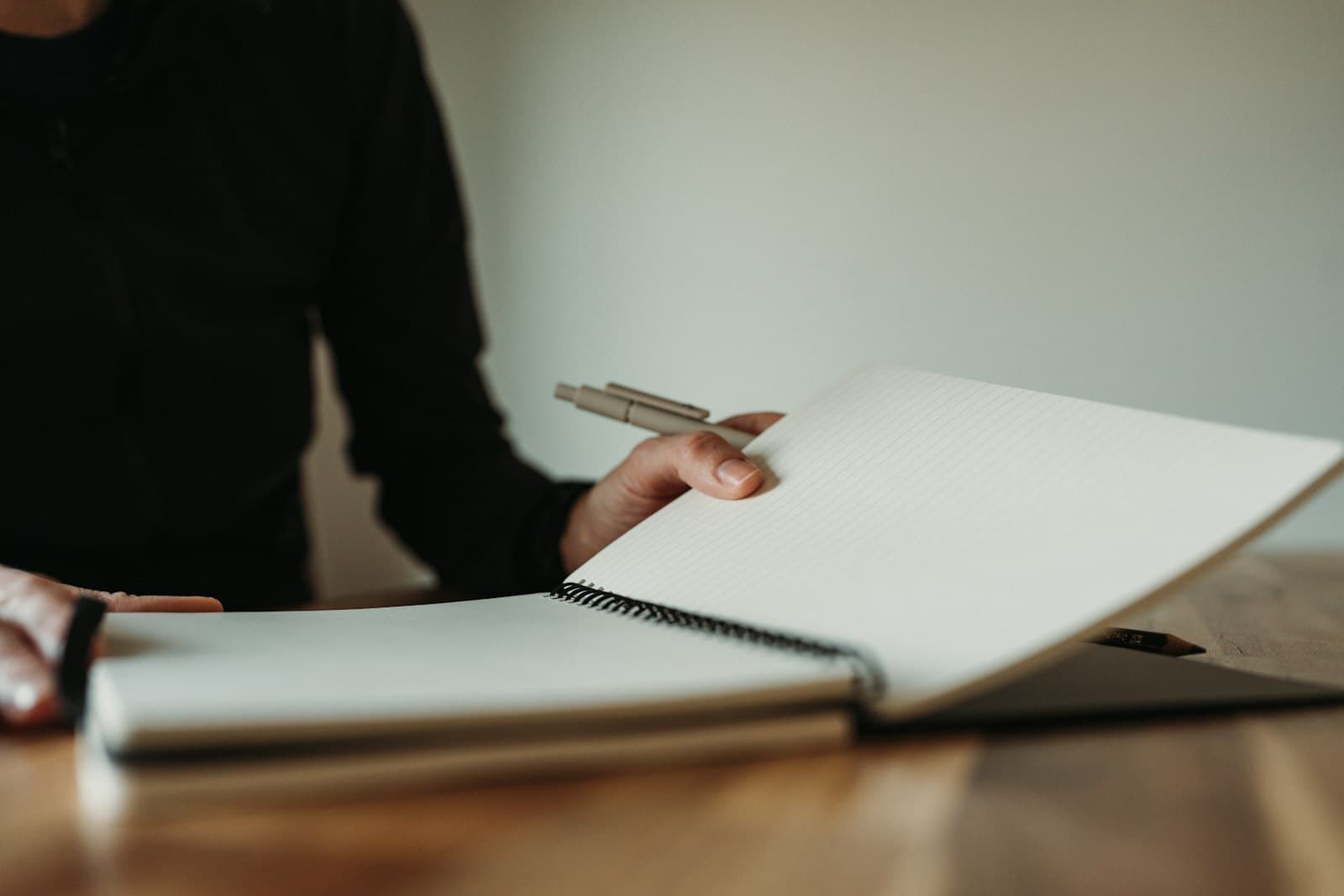A person writing in an open notebook